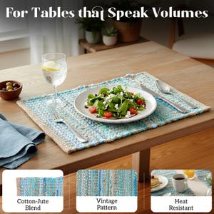 May include: A rectangular placemat made of a cotton-jute blend with a vintage pattern in shades of blue and beige. The placemat is on a wooden table, with a plate of salad, silverware, and a glass of water.