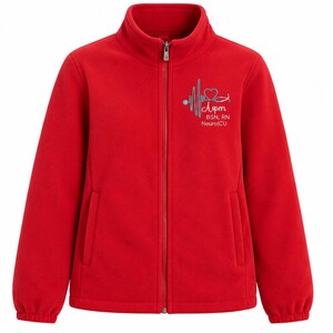 Pu&ograve; includere: Una giacca in pile rosso brillante con cerniera frontale a tutta lunghezza e colletto alto. Il petto sinistro presenta un disegno ricamato con una linea del battito cardiaco, un cuore, uno stetoscopio e il testo: Aspen, BSN, RN, NeuroICU.
