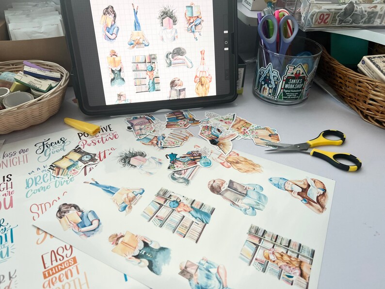May include: A sheet of stickers featuring illustrations of women reading books. The stickers are on a white background and include various quotes such as "Focus Good", "Positive Vibes", and "Easy Things Aren't Growth".