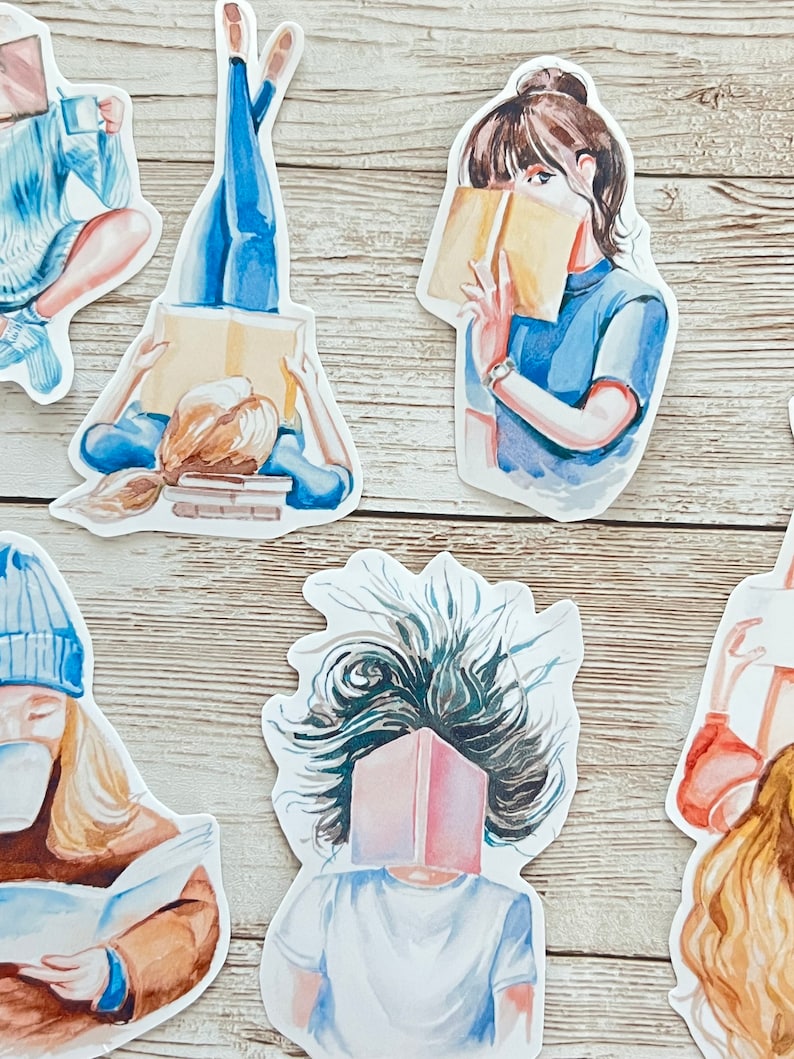 May include: A set of five watercolor stickers featuring women reading books. The stickers are on a light wood background. The women are depicted in various poses, some with their hair flowing in the wind, others with their hair pulled back. The books are all different colors and sizes.