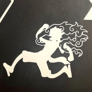 Puede incluir: Silueta blanca de una figura corriendo con pelo puntiagudo y un dise&ntilde;o en forma de llama alrededor de la cabeza y los brazos, sobre un fondo negro. La figura est&aacute; en movimiento, con una pierna extendida y los brazos levantados.