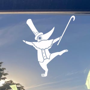 May include: White decal of a stylized plague doctor in a top hat, coat, and ruffled collar, holding a cane and posed in a ballet-like stance. The design is set against a blue sky background.