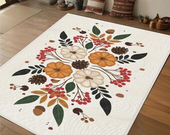 Puede incluir: Una alfombra rectangular con fondo crema y diseño otoñal. El diseño presenta calabazas naranjas y blancas, piñas, bayas rojas y hojas verdes y marrones. La alfombra está colocada sobre un suelo de madera.