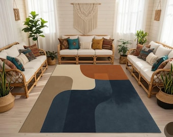 May include: A large area rug with a geometric design in shades of beige, brown, rust, and navy blue. The rug is placed in a living room setting with rattan sofas, decorative pillows, and potted plants, creating a cozy and inviting atmosphere.