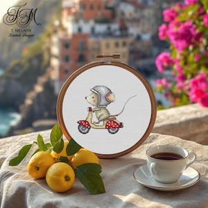 Könnte beinhalten: Ein Kreuzstich-Stickrahmen mit einer Cartoon-Maus auf einem Roller. Die Maus trägt einen Helm, und der Roller ist gelb und rot. Der Hintergrund umfasst Zitronen, eine Tasse Kaffee und den Text "T. Melnyk Xstitch Design".