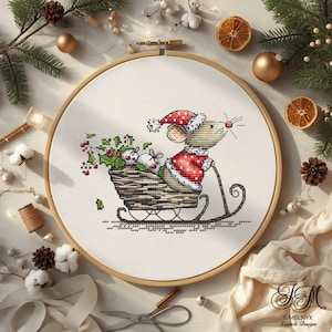 Könnte beinhalten: Kreuzstich-Stickerei einer Maus im Weihnachtsmann-Kostüm, die einen Schlitten voller Geschenke und Stechpalmen zieht. Das Design befindet sich in einem hölzernen Stickrahmen. Die Maus trägt einen rot-weißen Weihnachtsmannhut und -mantel. Der Schlitten ist braun.
