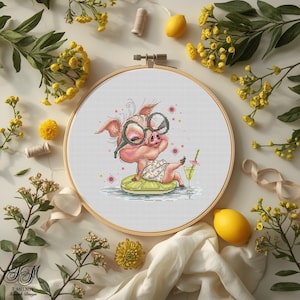 Könnte beinhalten: Ein Kreuzstich-Stickrahmen mit einem Cartoon-Schwein, das eine Brille und einen Badeanzug trägt und sich auf einer Limettenscheibe mit einem Cocktail entspannt. Das Design ist von gelben Blumen, Zitronen und Grün umgeben.