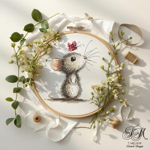 Peut inclure: Broderie au point de croix d'une souris avec un papillon rouge et blanc sur la tête, dans un cercle en bois. La souris est grise et blanche, avec de longues moustaches. Des fleurs blanches et des rubans entourent le cercle. Design de T. Melnyk Xstitch Design.