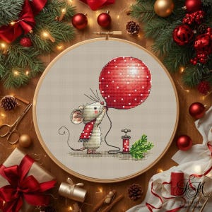 May include: A cross-stitch embroidery in a round wooden hoop featuring a light grey mouse wearing a red and white polka-dot scarf. The mouse holds a large red balloon with white dots, connected to a small red pump with a green pine sprig.