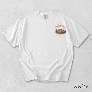May include: White t-shirt with a small graphic on the upper chest featuring the text "Yellowstone" above a mountain and tree scene. The word "white" is printed at the bottom right of the image.