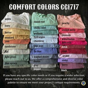 May include: Stacks of folded t-shirts in various colors, including white, ivory, butter, and mustard. The image displays a wide range of hues, from light greens to deep blacks, with each shirt labeled with its color name. The text "COMFORT COLORS CC1717" is at the top.