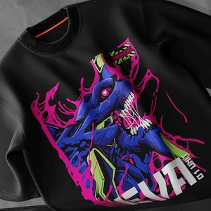 May include: Black sweatshirt with a striking graphic of a blue and purple creature, accented with pink. The design includes the text "01 UNIT" and "EMERGENCY TYPE". The sweatshirt has a crew neck and long sleeves. A bold, eye-catching design.