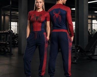 May include: Two athletic outfits featuring a red and blue spider-web pattern. One set includes a short-sleeved shirt and joggers, while the other features a long-sleeved shirt and joggers. Both tops display a large red spider emblem on the chest.