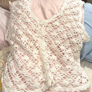 May include: A white ceramic mug with a black handle and the text "But First, Coffee" in a black, handwritten-style font. The mug is on a white surface.