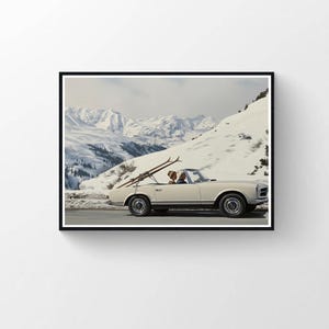 May include: A vintage cream-colored convertible car with skis attached, driving on a snowy mountain road. The car has two occupants and is set against a backdrop of snow-covered mountains and a cloudy sky. The image is framed in a black border.