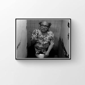 Könnte beinhalten: Schwarz-Weiß-Druck mit Rahmen, der einen Mann in einem Blumenhemd und einer Brille zeigt, der eine Waffe hält, während er sitzt. Das Bild ist ein Porträt eines Mannes in einem Badezimmer.