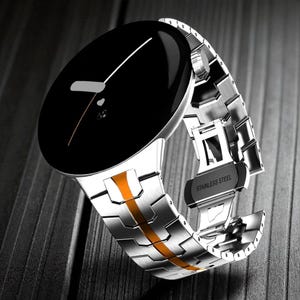 Può includere: Un orologio da polso moderno con quadrante nero e cinturino in acciaio inossidabile argentato. Il cinturino presenta una striscia arancione al centro. L'orologio ha un design minimalista con un'estetica elegante e contemporanea. La chiusura è contrassegnata "STAINLESS STEEL".