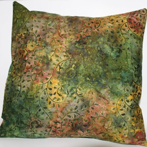 May include: A green, brown, and yellow patterned throw pillow with a floral design.