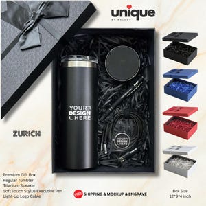 以下が含まれることがあります： YOUR DESIGN HEREという文字が入った黒いタンブラー、丸い黒いスピーカー、YOUR DESIGN HEREという文字が入った黒いペン、YOUR DESIGN HEREという文字が入った円形のタグ付きの黒い充電ケーブルが入った黒いギフトボックス。