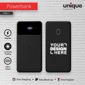 May include: Two black power banks are displayed against a white brick wall. One shows a digital display reading 100%, the other has the text "YOUR DESIGN L HERE". Features include MagSafe, luminous printing, and USB-C output.