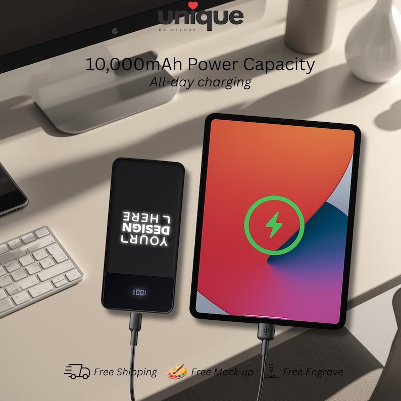 May include: A black rectangular power bank with a 10,000mAh capacity and a digital display showing 100 percent, connected via a black cable to a tablet displaying a green charging icon. The power bank features the white text DESIGN YOUR HERE.