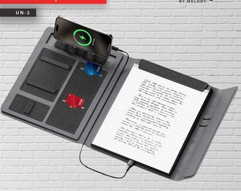 May include: Gray notepad with a built-in phone charger and card slots. The notepad has a charging phone and a paper pad with handwritten text. The word "Notepad" is in red text at the top. The brand name "unique" is also visible.