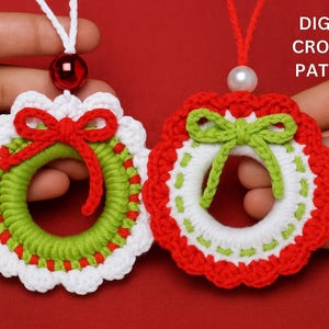 May include: Two handmade crochet Christmas wreath ornaments. One wreath has a red bow, the other has a green bow. Both have white, green, and red details. The text "DIGITAL CROCHET PATTERN" is visible. These ornaments are festive and decorative.