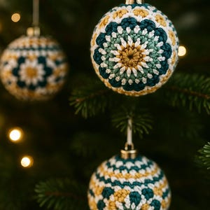 May include: Crocheted Christmas ornaments in shades of white, teal, and gold hang from a Christmas tree. The ornaments have a floral design and are suspended by white ribbons. The background is blurred with bokeh lights.