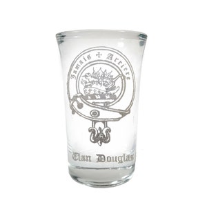 May include: A clear glass shot glass with a silver design of a crest and the text "Jamais Arriere Clan Douglas".