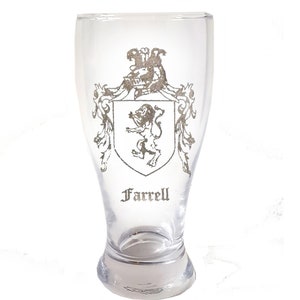 May include: A clear glass beer stein with a silver-colored coat of arms featuring a lion and the name "Farrell" printed on the front.