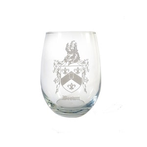 May include: A clear glass wine glass with an etched design of a coat of arms and the word "Brown".