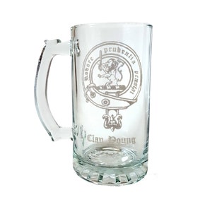 以下が含まれることがあります： 白いエッチングデザインが施された透明なガラス製のビアジョッキ。剣と盾を持ったライオンが描かれており、"Robore Prudentia Praesidi"と"Clan Young"の文字が刻まれています。