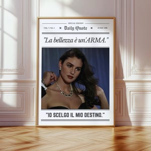 May include: A framed print with the text "Daily Quote" and the date "15 NOV 1991". The image features a woman wearing a necklace. The Italian text "La bellezza è un'ARMA" and "IO SCELGO IL MIO DESTINO" are also displayed.