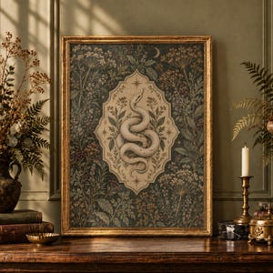 May include: A rectangular framed wall art piece featuring a coiled snake illustration centered within an ornate cream-colored cartouche, surrounded by a dark botanical background of wildflowers, ferns, and a crescent moon.