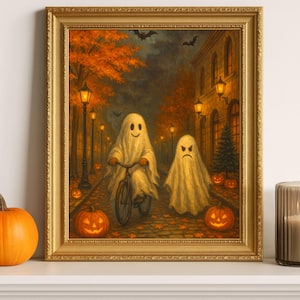Puede incluir: Un cuadro enmarcado con temática de Halloween representa dos fantasmas en una calle adoquinada con árboles y farolas. Un fantasma monta en bicicleta, el otro camina. Calabazas y murciélagos completan la escena.