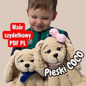 May include: Two beige crocheted dog plushies with black eyes and noses. One dog has a blue scarf, the other a pink bow. The text "Pieski Coco" is on the right. The text "Wzór szydełkowy PDF PL" is in a red box.