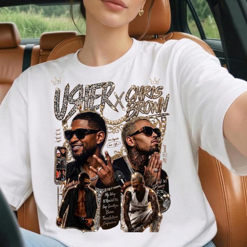 Pode incluir: Uma t-shirt branca de manga curta com uma impress&atilde;o gr&aacute;fica de Usher e Chris Brown. O design inclui texto em tom dourado, letras com padr&atilde;o de diamante e pequenas inser&ccedil;&otilde;es de fotos dos artistas. A impress&atilde;o cont&eacute;m t&iacute;tulos de m&uacute;sicas.
