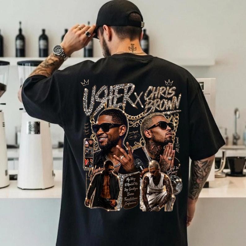Pode incluir: Uma t-shirt preta de manga curta com uma grande estampa gr&aacute;fica nas costas. O design inclui retratos de Usher e Chris Brown, detalhes de correntes douradas e o texto "USHER X CHRIS BROWN" numa fonte brilhante com coroas.