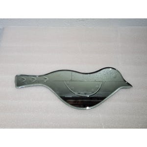 May include: A silver-toned bird-shaped mirror with a slightly curved design. The mirror is reflective and has a smooth surface.