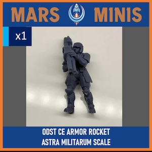 May include: A dark blue miniature figure of a soldier holding a rocket launcher. The figure is wearing armor and a helmet. The text "MARS MINIS" and "x1" are visible. The text "ODST CE ARMOR ROCKET ASTRA MILITARUM SCALE" is also present.