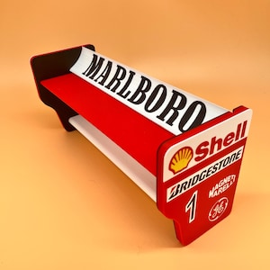 May include: A red, white, and black decorative shelf with the word "MARLBORO" in bold black letters. The shelf also features the Shell logo, "BRIDGESTONE", and the number "1".