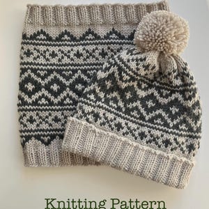 May include: A knitted hat and neck warmer set in beige, gray, and white. The hat has a pom-pom and a geometric pattern. The neck warmer has a similar design. The text "Knitting Pattern" is at the bottom.