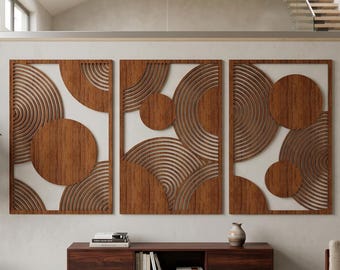 May include: A set of three rectangular wall art panels featuring a dark brown wood grain finish. Each panel displays a geometric composition of solid circles and concentric semi-circular line patterns, creating a layered, open-work design.