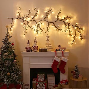 Könnte beinhalten: Eine festliche Weihnachtsszene mit einem geschmückten Baum, einem Kamin mit Strümpfen und einer astförmigen Lichterkette. Der Kaminsims beherbergt Ornamente und Kerzen und schafft eine warme, einladende Urlaubsatmosphäre.