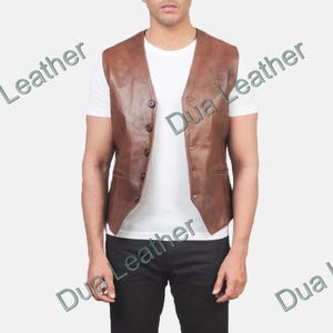 Peut inclure: Un gilet en cuir marron avec un col en V et une fermeture boutonnée. Le gilet a deux poches avant et est porté sur un t-shirt blanc. Un style classique, adapté à diverses occasions.