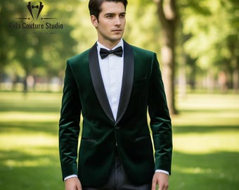 Puede incluir: Un blazer de terciopelo verde oscuro con solapa de satén negro, combinado con una camisa blanca y una pajarita negra. El blazer es entallado y tiene un corte clásico. La imagen también muestra pantalones de vestir grises. El logotipo de Rida Couture Studio está en la esquina superior izquierda.