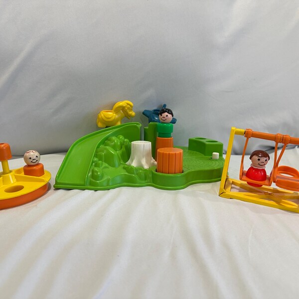 May include: A colorful children's playset featuring a yellow and orange carousel, a green slide, and a yellow swing set. The playset includes small plastic figures and a yellow horse. The carousel and swing set have figures seated in them.