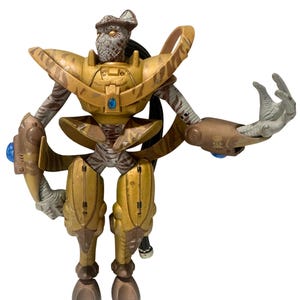 May include: A detailed action figure of a humanoid alien with a reptilian head and segmented body. The figure is primarily gold and brown, with blue accents. The figure has articulated limbs and a dynamic pose, suggesting action.