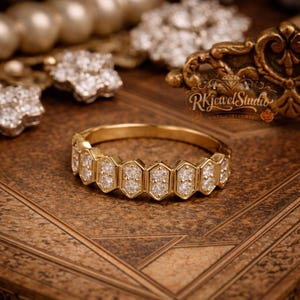 Art Deco hexagon diamond band in gold displayed on vintage textured surface, featuring geometric settings with sparkling round stones in a continuous elegant design