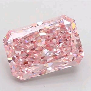 Può includere: Un diamante rosa taglio radiant, di forma rettangolare con angoli tagliati. La gemma presenta numerose sfaccettature che riflettono la luce, creando un effetto scintillante. Il colore è rosa tenue.